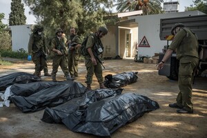 Ізраїльські солдати збирають тіла мирних жителів, убитих бойовиками ХАМАС у суботу в селі Кфар-Аза